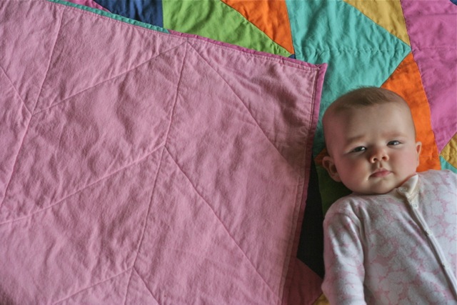 Baby with back of Triangle Quilt